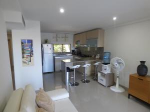 a living room with a kitchen with a refrigerator and a table at Puesta del sol in Santa Marta