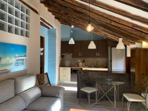 a kitchen and living room with a couch and a table at AIRAM Home BUHARDILLA in Almansa