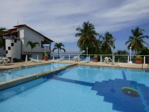 a large swimming pool with the ocean in the background at Puesta del sol in Santa Marta