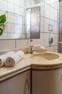 a bathroom with a sink and a mirror at Pousada Residencial dos Corais in Bombinhas +53 photos