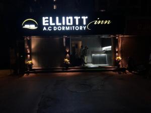 een man die 's nachts in de deuropening van een winkel staat bij ELLIOTT INN A.C DORMITORY in Mumbai