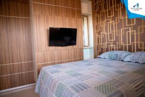1 dormitorio con 1 cama y TV en la pared en Via Caldas Lacqua IV, en Caldas Novas
