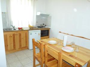 a kitchen with a wooden table with plates on it at Katerina Apartments in Tsoukaladhes