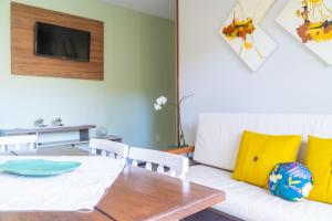 a living room with a white couch and a table at Pousada Residencial dos Corais in Bombinhas