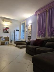 a living room with purple curtains and a couch at Memories B&B in Ferrara