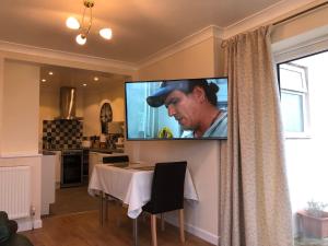 a living room with a tv with a man on it at Seaclusion in St Austell