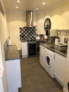 a kitchen with a washer and dryer at Seaclusion in St Austell