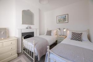 a bedroom with two beds and a fireplace at Bonheur in Southwold