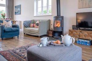 a living room with a fireplace and a couch and a table at The Artist's House in Orford