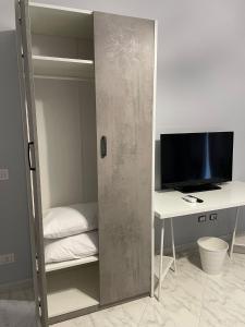 Camera con armadio, scrivania e TV. di Affittacamere Iria a Pomigliano dʼArco