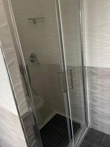 una doccia con porta in vetro in bagno di Affittacamere Iria a Pomigliano dʼArco
