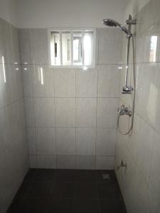 a bathroom with a shower with a window at Maison Charlotte Forever Chambre d'hôtes chez un couple belgo togolais in Lomé