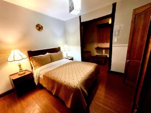 a hotel room with a bed and two lamps at Hotel Cantuña in Quito +7 photos