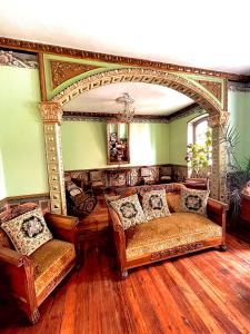 a living room with two couches and a mirror at Hotel Boutique Portal de Cantuña in Quito