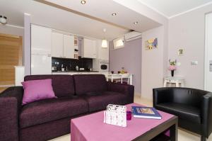 a living room with a purple couch and a table at Apartments Gaura in Dubrovnik