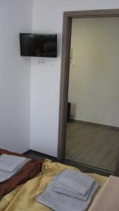 a room with a bed and a television on a wall at HZ Apartman Miskolc in Miskolc