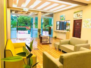 a living room with couches and chairs and a television at Sri Embun Resort Langkawi in Pantai Cenang