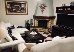 a living room with two white couches and a fireplace at Casa grande con piscina in Rota