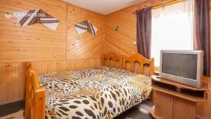 Dormitorio con cama de leopardo y TV en Сонне Царство, en Vorokhta