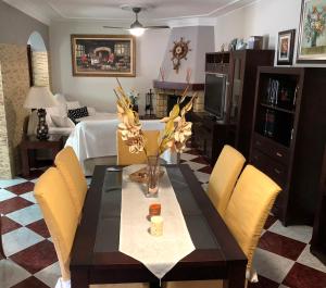 a dining room with a table with yellow chairs at Casa grande con piscina in Rota