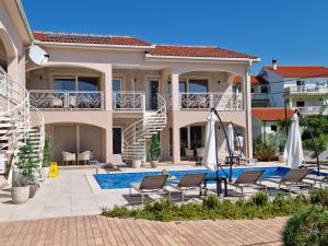 a villa with a swimming pool and chairs at Villa Luka Lopar in Lopar