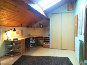 an attic office with a desk and a sliding glass door at Au Monde de Maëlle in Saint-Hippolyte