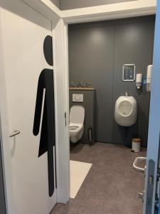 een badkamer met een toilet en een urinoir bij Ecolodge Zen Otra Cosa in Mouscron