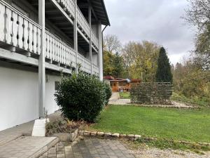 a white building with a yard next to a house at Villa Talblick im Naturpark Altmühltal in Greding