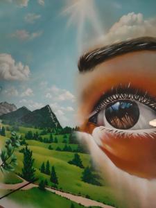 una pintura de un ojo de mujer mirando una montaña en Mírame Casa Vacanza, en Ovindoli
