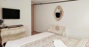 1 dormitorio con 1 cama, vestidor y TV en Mírame Casa Vacanza, en Ovindoli