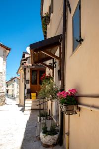 un vicolo con piante in vaso sul lato di un edificio di Mírame Casa Vacanza a Ovindoli