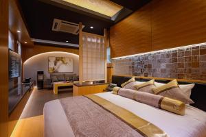 HOTEL Dior7つくば في تسوشيورا: غرفة نوم بسرير كبير وغرفة معيشة