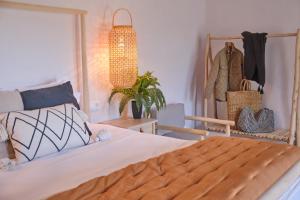 a bedroom with a bed and a rack of clothes at Apartamentos Cortijo Peñardera in Siles