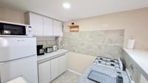 a small kitchen with white cabinets and a white refrigerator at 4 Soles in San Carlos de Bariloche