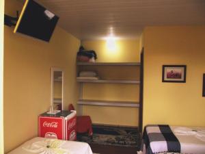 una camera con una scatola di coca cola e una TV di Pousada TonaPraia a Florianópolis