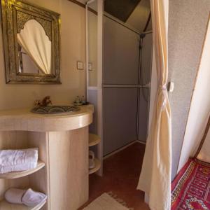 a bathroom with a sink and a mirror at Sahara Tours luxury camp in Merzouga +40 photos