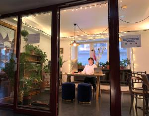 a person sitting at a table with a laptop at Pop Up Hotel Krone Zürich in Zurich