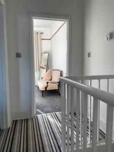 pasillo con espejo y silla en una habitación en Cosy 2 Bedroom House -2022 & 2023 Award Winner! en Ramsgate