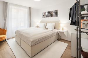 a white bedroom with a bed and a window at EH Apartments Neptun in Chur