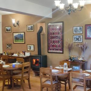 BanjārにあるKudrat - A Boutique Homestay- Tirthan Valleyのダイニングルーム(暖炉、テーブル、椅子付)
