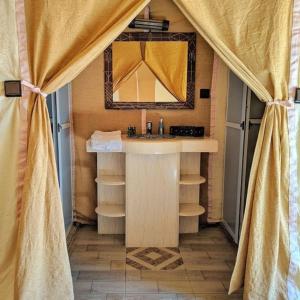 a bathroom with a sink and a mirror at Deep Desert Camp in Merzouga