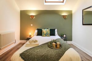 a bedroom with a large bed with a green wall at 3 Bedroom City Centre Townhouse in Nottingham