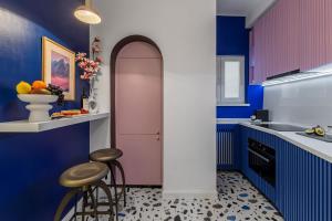 une cuisine avec une porte rose et deux tabourets dans l'établissement HOLT - Birds of Paradise, à Bucarest