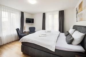 a hotel room with a large bed and a chair at EH Apartments Venus in St. Gallen