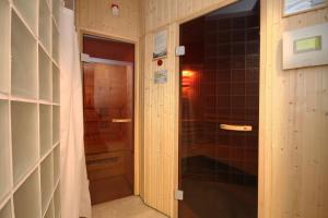 pasillo con puerta a una ducha en una habitación en ApartSerwis - Apartament Paryski, en Zakopane