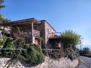 a stone house with a balcony on a stone wall at The Artist's House in Psárion