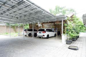 a garage with three cars parked under awning at RedDoorz near Sleman City Hall 3 in Yogyakarta