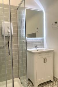 a bathroom with a sink and a shower with a mirror at Hidden Hills Waterville - Private Farmhouse in Waterville