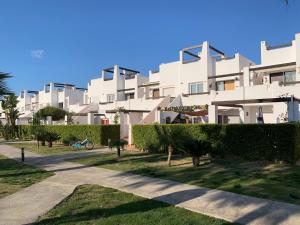 a large white building with bushes in front of it at Naranjo 7 - N565 - 2 bathrooms Apartment in Alhama de Murcia Golf Resort in Alhama de Murcia