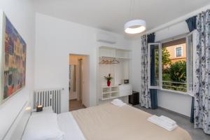 une chambre avec un lit blanc et une fenêtre dans l'établissement Sant'Erasmo Suite, à Rome
